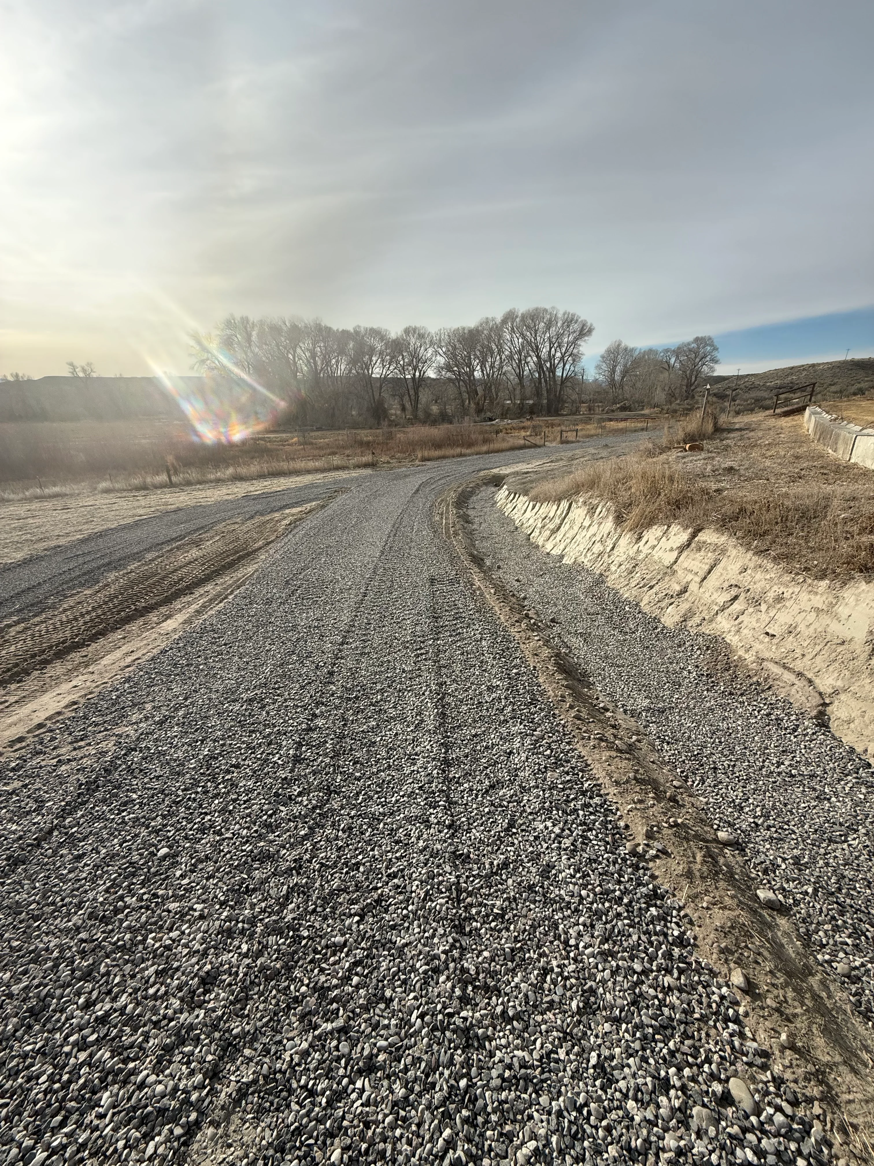 Gravel driveway with compacted stone base and reinforced edge on rural property