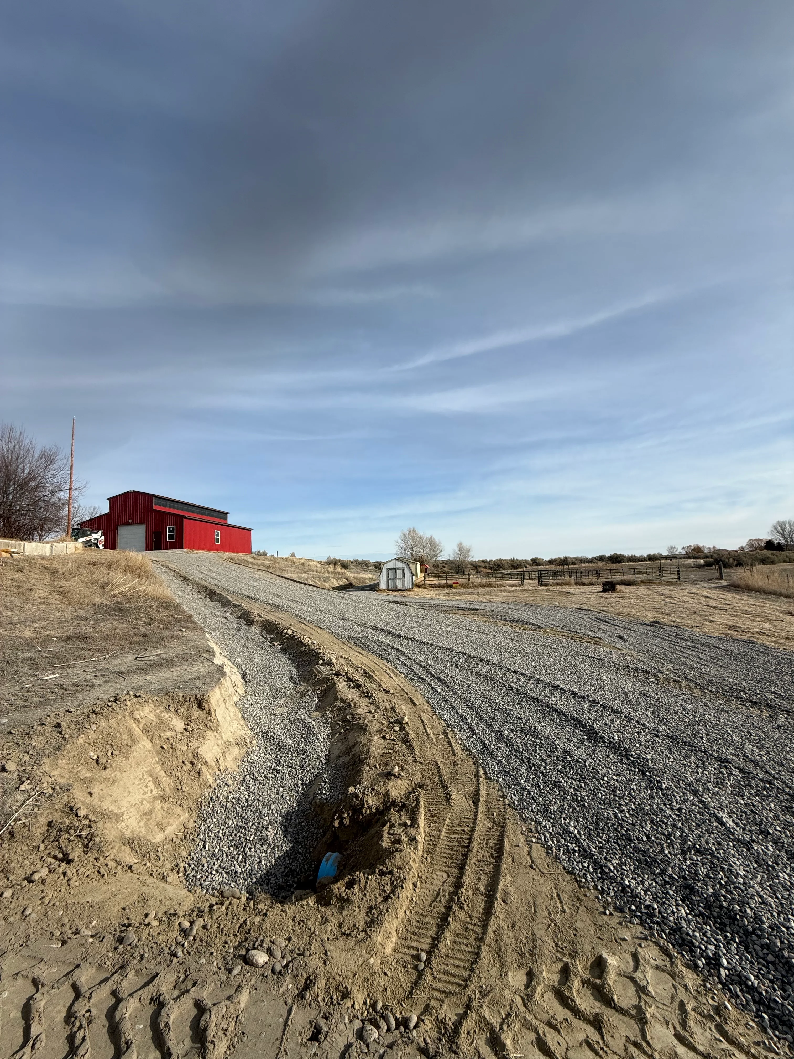 Gravel driveway with compacted stone base and finished surface on rural property